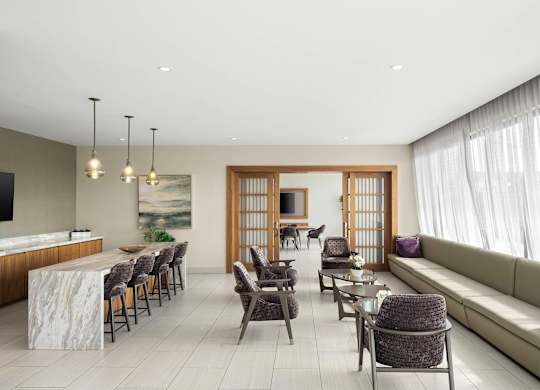 A modern living room with a dining area and a large window. at Palma, Doral