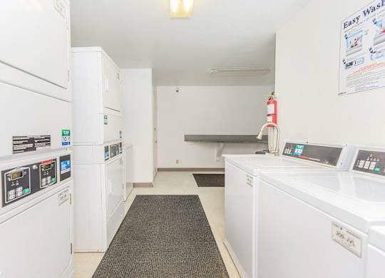 A laundromat with a row of washers and dryers.