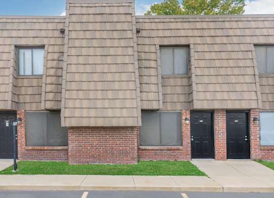 A building with a brown shingled roof and black doors.
