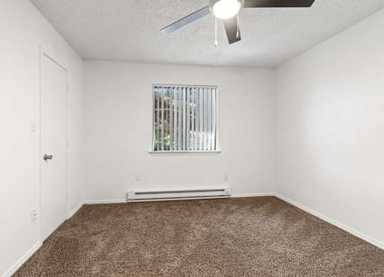 A room with a window and a ceiling fan.