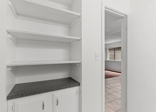 Empty white shelves in a kitchen.