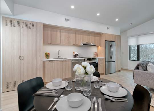 A modern dining room with a table set for two at The Grove Apartments, Ontario, L3V 1H4