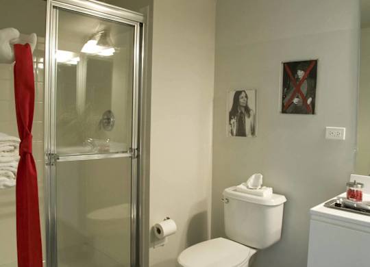 A bathroom with a toilet, a sink, and a shower.at 66 Main, New York