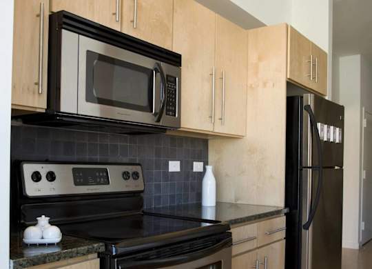 A kitchen with black appliances and wooden cabinets.at 66 Main, New York, 10701