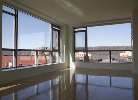 A large empty room with a view of the outside through large windows.at 66 Main, New York, 10701