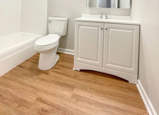 A white toilet sits next to a sink in a small bathroom.