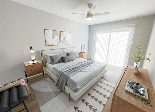 A bedroom with a large bed, a ceiling fan, and a chair.