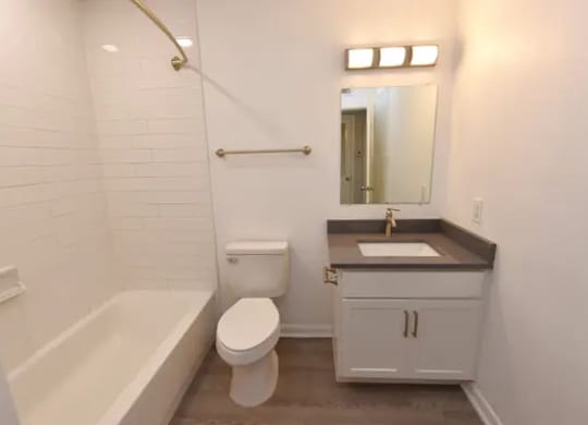 A white bathroom with a toilet, sink, and bathtub.