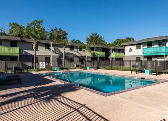 A swimming pool in front of apartment buildings.