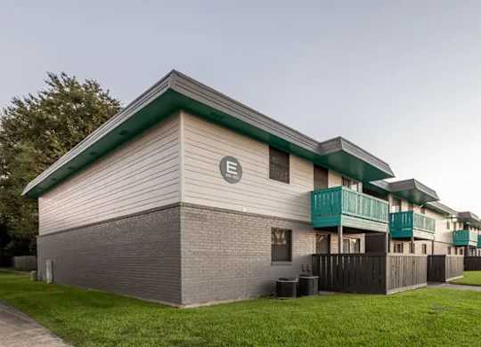 A building with a green roof and a sign with the letter E on it.