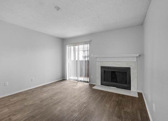 A room with a fireplace and a window with blinds.