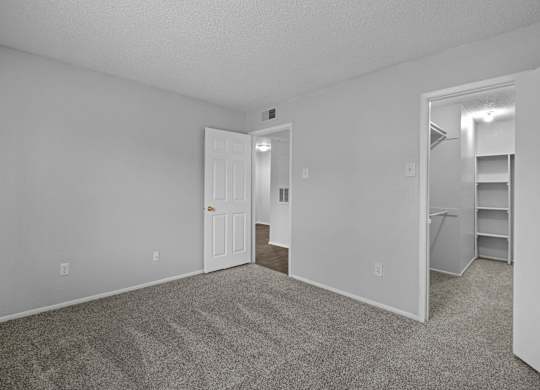 A room with a door and a shelf in it.