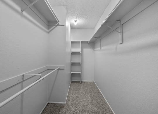 A white hallway with a carpeted floor and a metal railing on the left side.