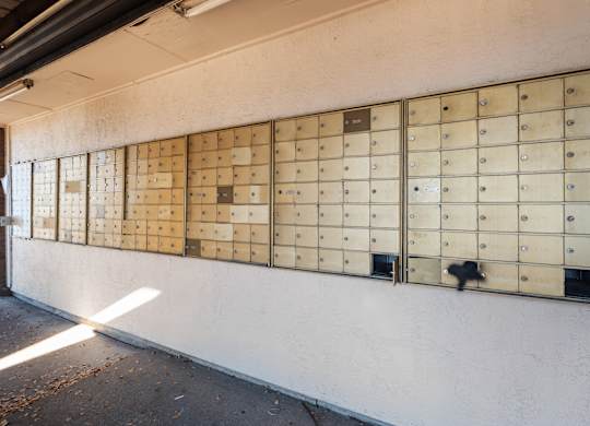 A wall of mailboxes on a white wall.