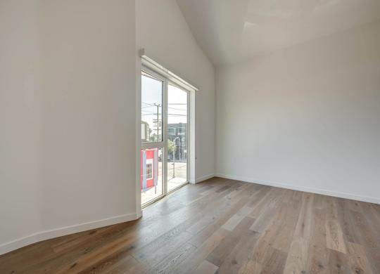A room with wooden flooring and a large window.at 5263 W Adams, Los Angeles, 90016