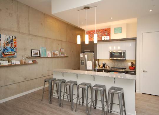 A kitchen with a bar stool in front of it.