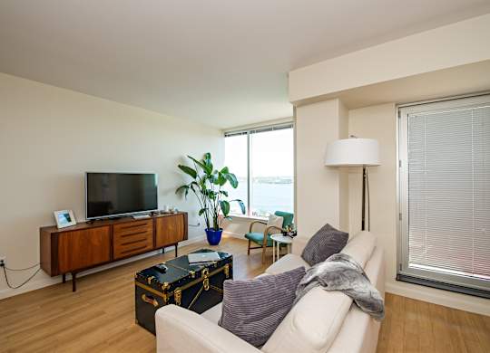 A living room with a white couch and a wooden cabinet.