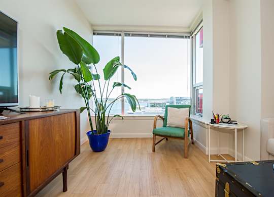 A room with a green chair and a blue pot.