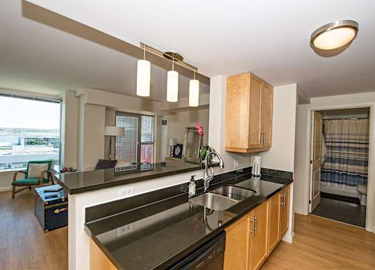 A kitchen with a black counter top and wooden cabinets.