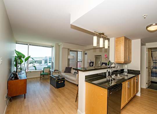 A kitchen with a black counter top and wooden cabinets.