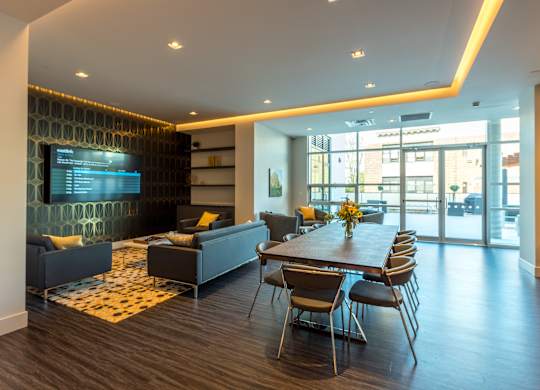 A modern living room with a long table and chairs.