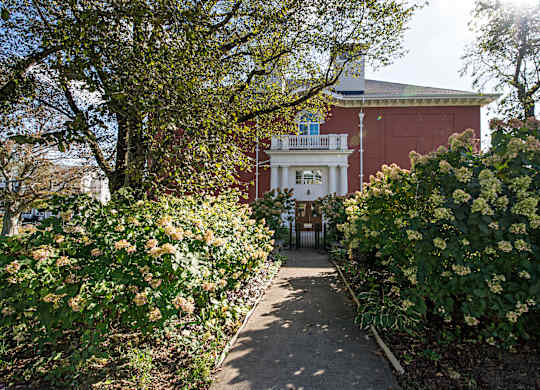 A pathway leads to a building with a balcony.