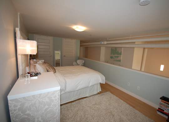 A bedroom with a bed, nightstand, and lamp.