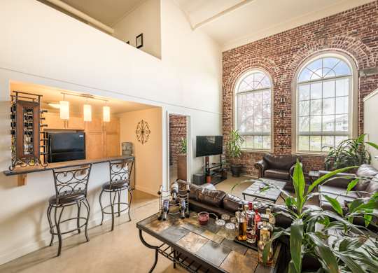 A living room with a brick wall and a large window.