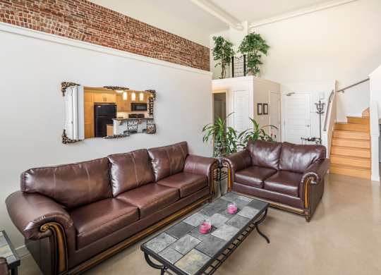 A living room with a brown leather couch and a coffee table.