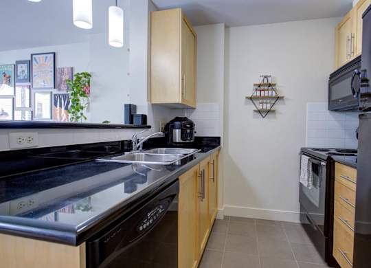 A kitchen with black appliances and wooden cabinets.