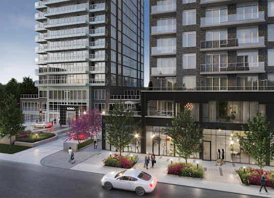 A modern apartment building with a car parked in front of it.