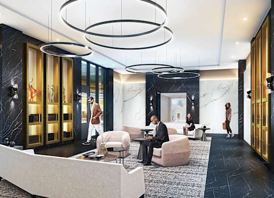 A man in a suit is sitting in a chair in a modern lobby.