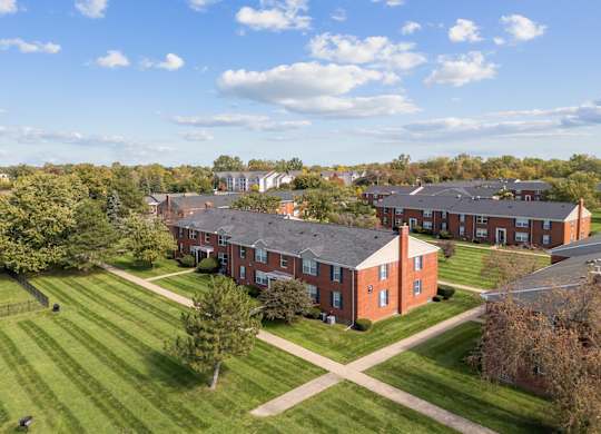 A large red brick building with a green lawn in front.