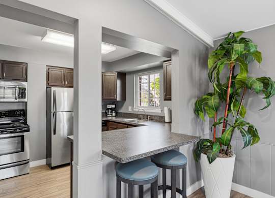 A kitchen with a stainless steel refrigerator and oven.