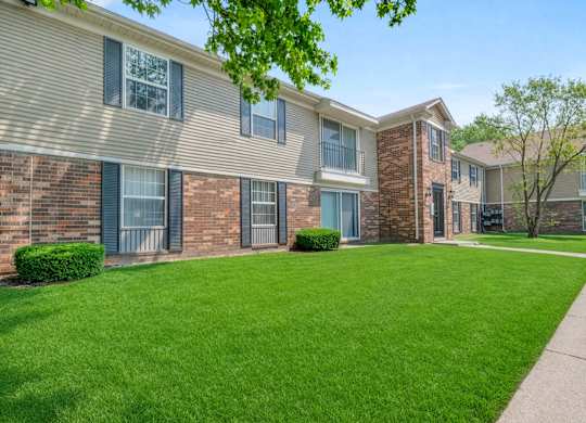 Apartment complex with green lawn in front.