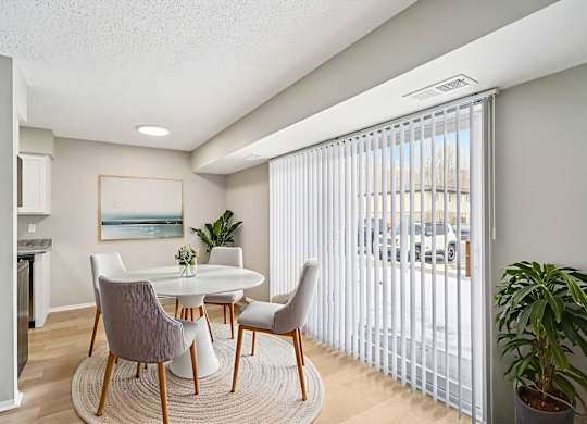 A dining room with a white table and chairs.