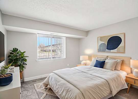 A bedroom with a large bed and a painting on the wall.