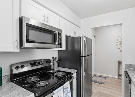 A kitchen with a black stove top oven and a black refrigerator.