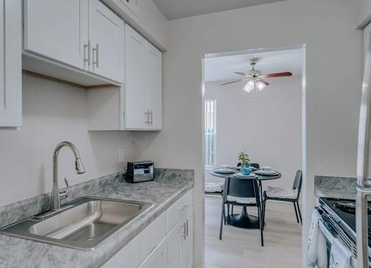 A kitchen with a marble countertop and a ceiling fan.