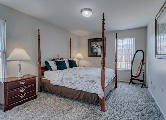 A bedroom with a four poster bed and a window.