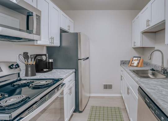 A kitchen with a blue stove top and white cabinets.