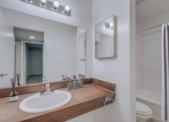 A bathroom with a sink, mirror, and toilet.