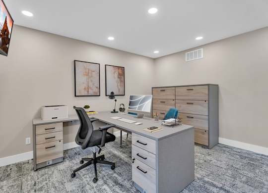 A modern office with a desk, chair, and filing cabinet.