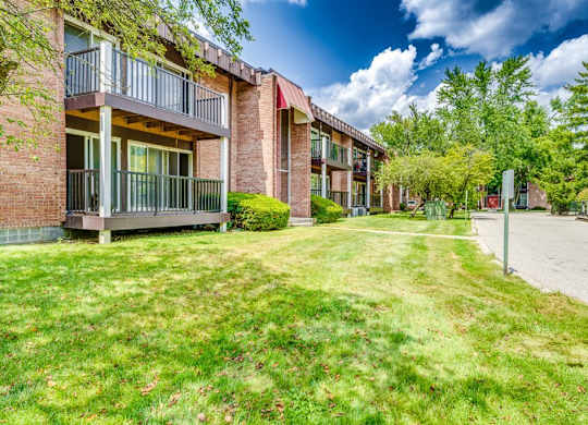 A row of apartment buildings with green lawns in front.