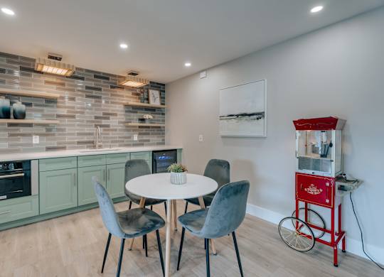 A kitchen with a table and chairs and a red cart.