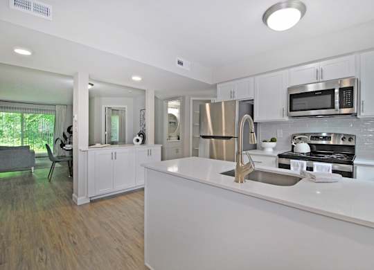 A modern kitchen with white cabinets and stainless steel appliances.