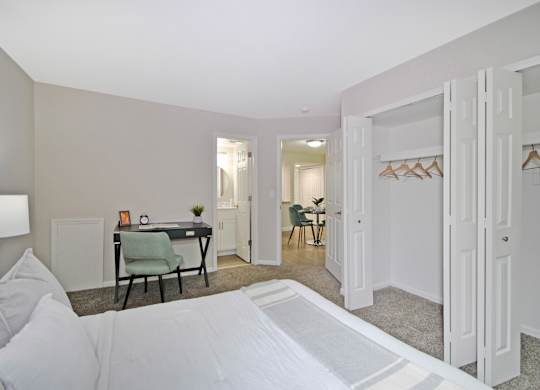A bedroom with a bed, desk, and chair.
