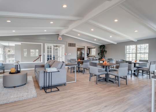 A spacious living room with grey furniture and a wooden floor.