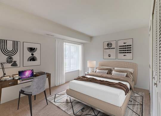 A bedroom with a bed, desk, and chair.