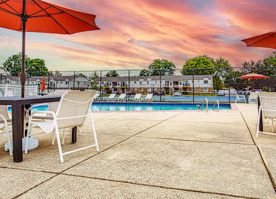 A pool area with chairs and umbrellas is shown.